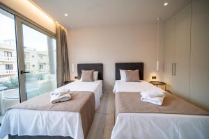 two beds sitting next to each other in a room at Imperial House - Hersonissos Center - Sleeps 8 in Hersonissos