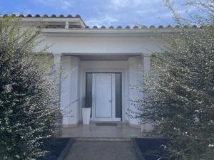 a white house with a white door and a plant at Casa com ALma in Fátima