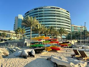 a beach with boats in front of a building at Luxury private sea view room in Abu Dhabi