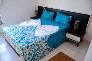 a bed with blue and white sheets and pillows at Apartamento T2 Equipado e Aconchegante. in Praia