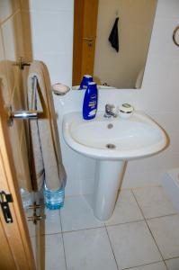 a bathroom with a white sink and a toilet at Apartamento T2 Equipado e Aconchegante. in Praia