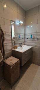 un bagno con un lavandino, uno specchio e uno sgabello di Quinta Alcarias a Santa Catarina da Fonte do Bispo Altre 13 foto