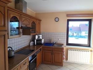 uma cozinha com armários de madeira, um lavatório e uma janela em Vermietung Hänsel em Thiendorf