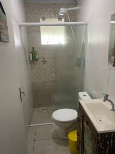uma casa de banho com um chuveiro, um WC e um lavatório. em Casa em Pontal do Paraná em Pontal do Paraná