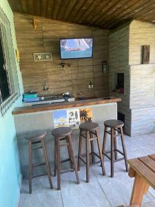 uma cozinha com três bancos de bar e um lavatório em Casa em Pontal do Paraná em Pontal do Paraná