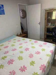 Un dormitorio con una cama con flores. en Casa em Pontal do Paraná en Pontal do Paraná