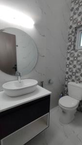 a bathroom with a sink and a toilet and a mirror at SP HOMES Guest House in Islamabad