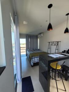 Un dormitorio con una cama y un escritorio en una habitación. en Eco Loft Brisa do Mar, en Cabo Frío