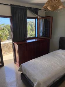 ein Schlafzimmer mit einem Bett und einem großen Fenster in der Unterkunft Appartement vue sur mer Résidence Marsa M’diq in Mʼdik
