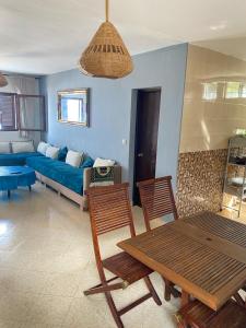 ein Wohnzimmer mit einem blauen Sofa und einem Tisch in der Unterkunft Appartement vue sur mer Résidence Marsa M’diq in Mʼdik
