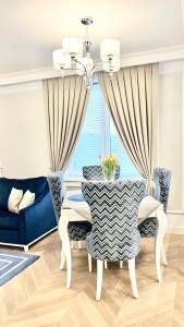 a dining room with a table and a blue couch at Apartament BIANCO Royal in Częstochowa +12 photos