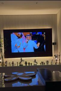 TV de pantalla plana en la pared de una habitación en A luxury three-bedroom apartment in the heart of Riyadh en Riad
