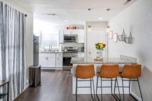 a kitchen with a counter and some orange chairs at Remodeled Home w/ King Bed, Bunk Bed, & Yard Games in Concord