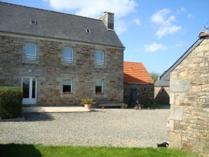 a large stone building with a dog in front of it at La route bleue in Ploumilliau