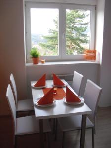 een tafel en stoelen met rode servetten erop bij Apartmán Linda in Lipno nad Vltavou