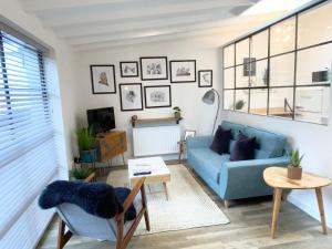 a living room with a blue couch and a table at The Old Bakery in Norwich