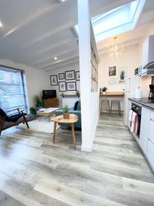 a living room with a table and a kitchen at The Old Bakery in Norwich