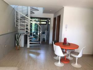 a room with a table and chairs and a staircase at Bangalô em Corais de Carapibus in Conde