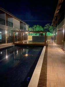 a swimming pool in a building at night at Bangalô em Corais de Carapibus in Conde