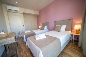 two beds in a hotel room with pink walls at Luxury House - Hersonissos Center - Sleeps 8 in Hersonissos