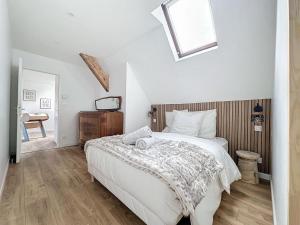 ein Schlafzimmer mit einem großen weißen Bett und einem Dachfenster in der Unterkunft PARENTHESE - Bagnères-de-Bigorre in Bagnères-de-Bigorre