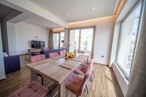 a dining room with a wooden table and pink chairs at Luxury House - Hersonissos Center - Sleeps 8 in Hersonissos