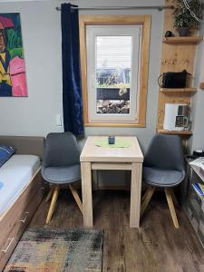 a room with a table and two chairs and a window at Tiny House Black Pearl in Tettnang