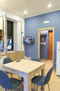 ein Esszimmer mit einem Tisch und blauen Wänden in der Unterkunft Le Terrazze sul Vesuvio in Neapel