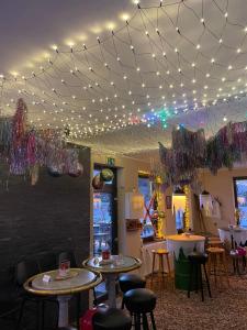 a restaurant with tables and chairs under a ceiling with lights at Pension zur Quelle in Deudesfeld