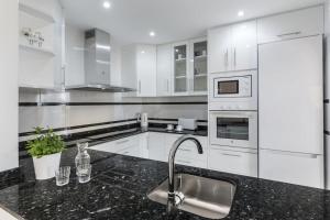 a kitchen with white appliances and a black counter top at La Manga Club Resort - Los Olivos 68 in Atamaría