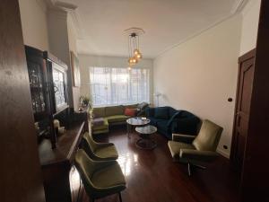 a living room with a couch and chairs and a table at Charmante Art Deco rijwoning in Ostend