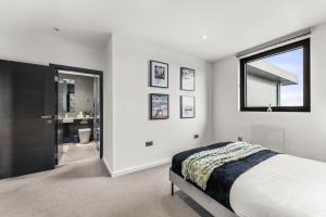 a bedroom with a bed and a window and a bathroom at Beautiful Chelmsford Penthouse with Balcony in Chelmsford