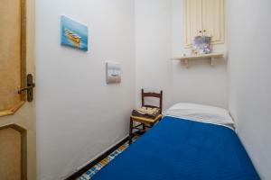 Un dormitorio con una cama azul y una silla. en Casa Simona - Positano Center - 5 min to the beach, en Positano 41 fotos más