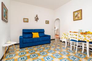 Una sala de estar con un sofá azul y una mesa. en Casa Simona - Positano Center - 5 min to the beach, en Positano
