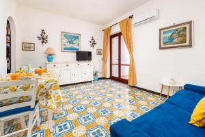Una sala de estar con un sofá azul y una mesa. en Casa Simona - Positano Center - 5 min to the beach, en Positano