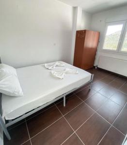 a white bed in a room with a window at Elvi Apartment 5 in Áyios Yeóryios