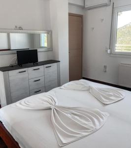 a large white bed in a bedroom with a window at Elvi Apartment 5 in Áyios Yeóryios