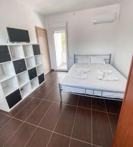 a bedroom with a white bed and a tiled floor at Elvi Apartment 5 in Áyios Yeóryios