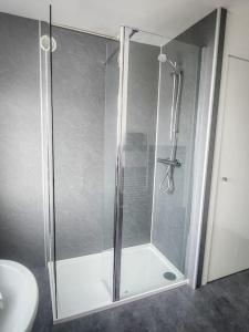 a shower with a glass door in a bathroom at Central 2-bedroom bunglow with double sofa bed in Carnoustie