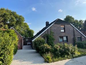 a brick house with a walkway in front of it at FeWo Deichblick - Javenloch in Wittmund