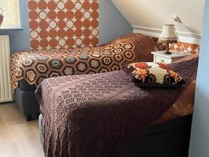 a bedroom with two beds and a table with a lamp at B&B Het Oude Dorpscafé in Zorgvlied