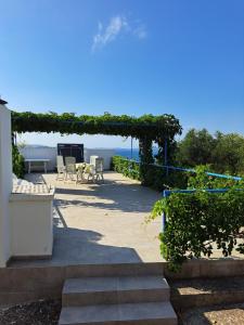 a patio with a pergola and a table and chairs at Olivier house in Zaglav