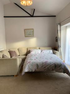 a bedroom with a bed and a couch at The Barn at White Rose Cottage in Towcester