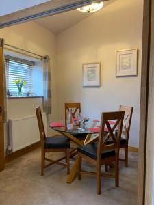 a dining room with a table and chairs at The Barn at White Rose Cottage in Towcester