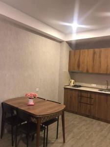 a kitchen with a wooden table and a table and chairs at bakuriani didveli rezidensi G6 in Borjomi