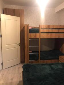 a room with two bunk beds and a door at bakuriani didveli rezidensi G6 in Borjomi