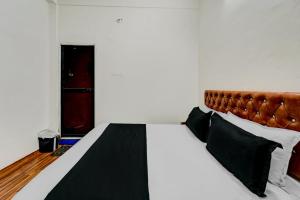 een slaapkamer met een groot bed met een bruin hoofdeinde bij OYO Flagship Hotel Blue Moon in Patna