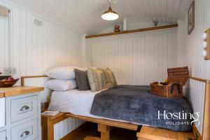 a bedroom with a bed and a table with pillows at One Of A Kind Shepherds Hut With Incredible Views in Thame