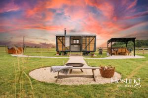a tiny house in a field with a picnic table at One Of A Kind Shepherds Hut With Incredible Views in Thame
