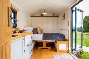 ein Zimmer mit einem Bett in einem winzigen Haus in der Unterkunft One Of A Kind Shepherds Hut With Incredible Views in Thame